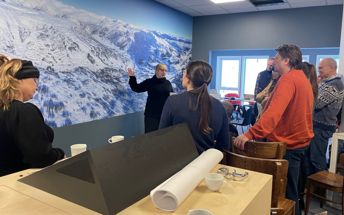 Kvinneleg forskar forklarer og peikar på kart over fjellområde