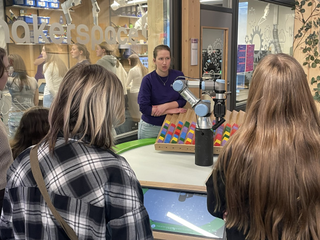 Jenter ser på sorteringsrobot